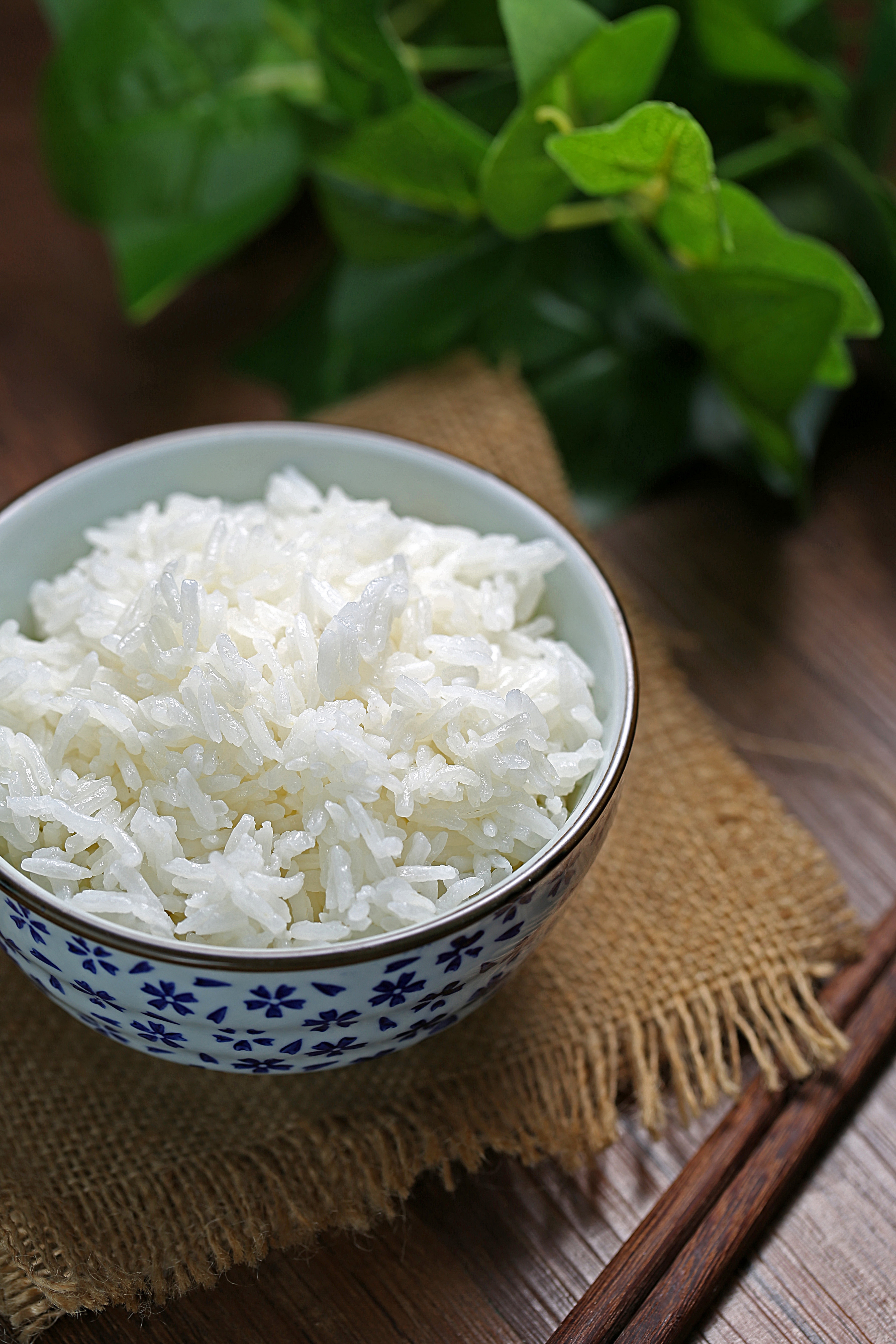 Fragrant Thai coconut rice served in a blue and white patterned bowl, placed on a rustic hessian mat, capturing a homely, aromatic presentation